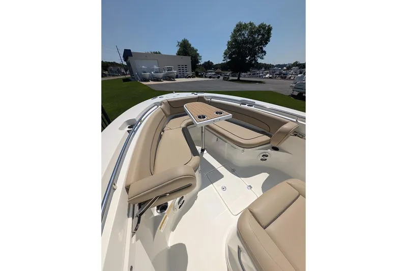 Slide: The Image of 2020 NauticStar 2602 Legacy boat interior with beige seating and a central table. - 22