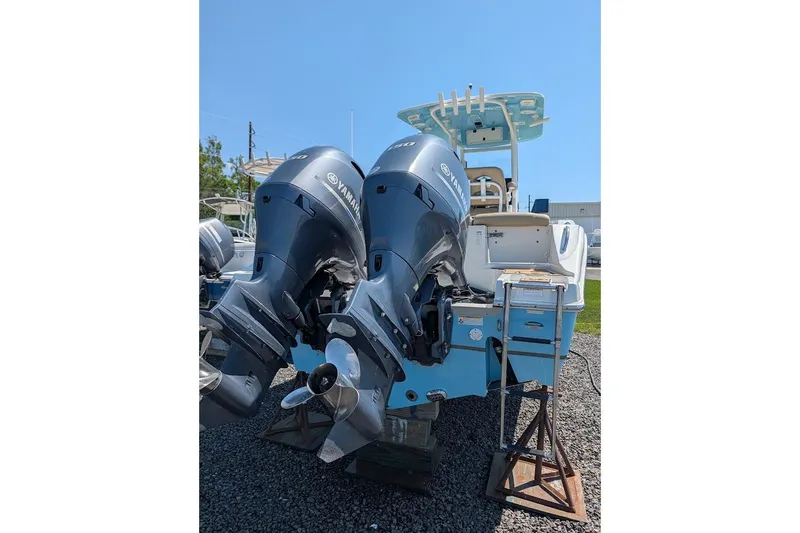 Slide: The Image of 2020 NauticStar 2602 Legacy boat with dual Yamaha outboard engines, displayed outdoors. - 2