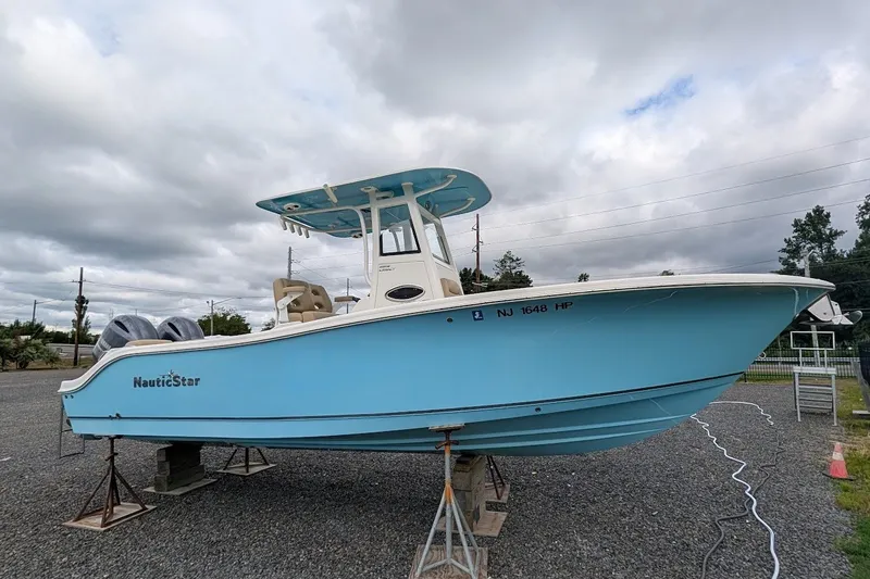 Slide: The Image of 2020 NauticStar 2602 Legacy boat in light blue, displayed on stands outdoors. - 1