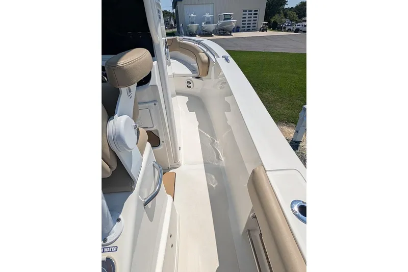 Slide: The Image of 2020 NauticStar 2602 Legacy boat interior with beige seating and white deck. - 21