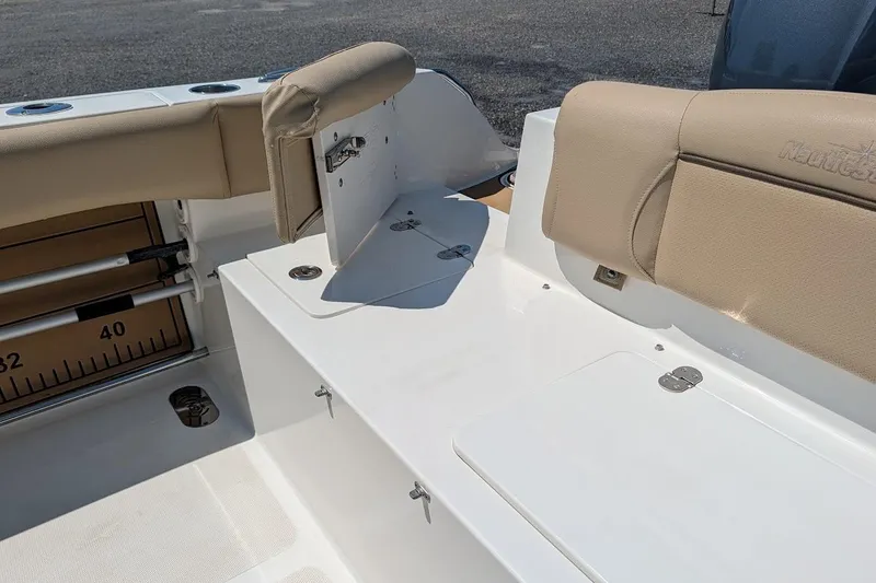 Slide: The Image of 2020 NauticStar 2602 Legacy boat seating area with beige cushions and storage compartments. - 5
