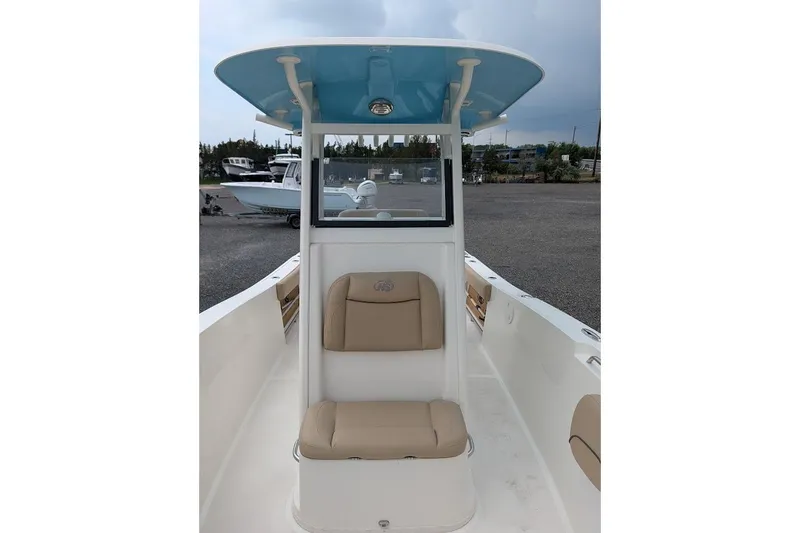 Slide: The Image of 2020 NauticStar 2602 Legacy boat interior with beige seating and blue T-top. - 11