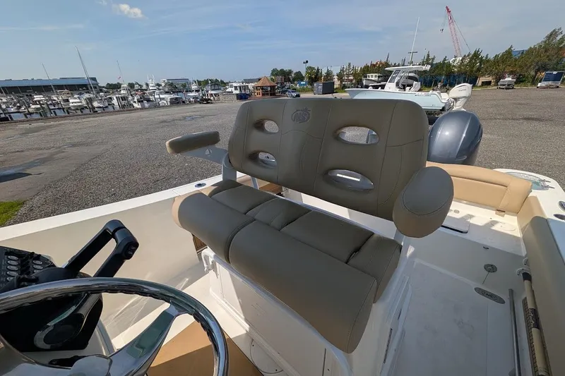 Slide: The Image of 2020 NauticStar 2602 Legacy boat interior with comfortable seating at marina. - 9