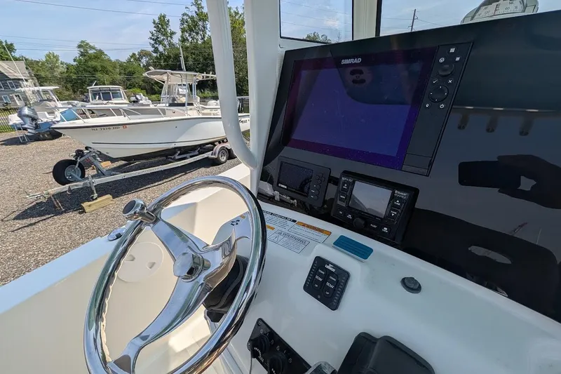 Slide: The Image of 2020 NauticStar 2602 Legacy boat dashboard with steering wheel and navigation display. - 7