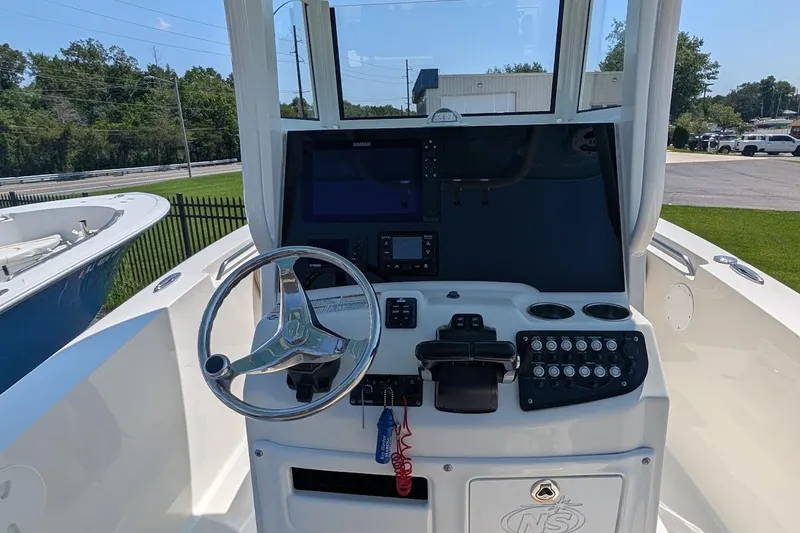 Slide: The Image of 2020 NauticStar 2602 Legacy boat dashboard with steering wheel and control panel. - 10