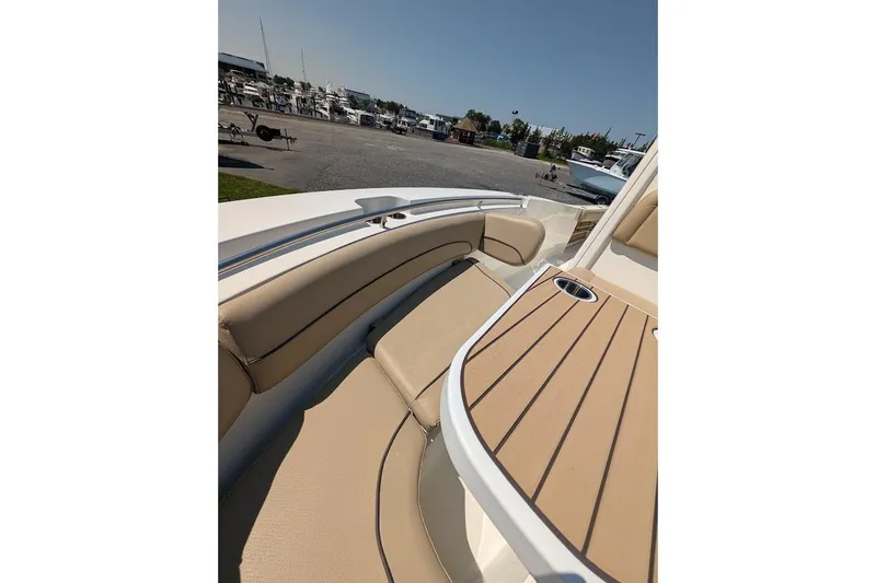 Slide: The Image of 2020 NauticStar 2602 Legacy boat interior with tan seating and wooden table. - 28