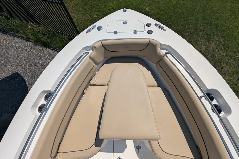 Slide: The Image of 2020 NauticStar 2602 Legacy boat with beige cushioned seating and stainless steel accents. - 27