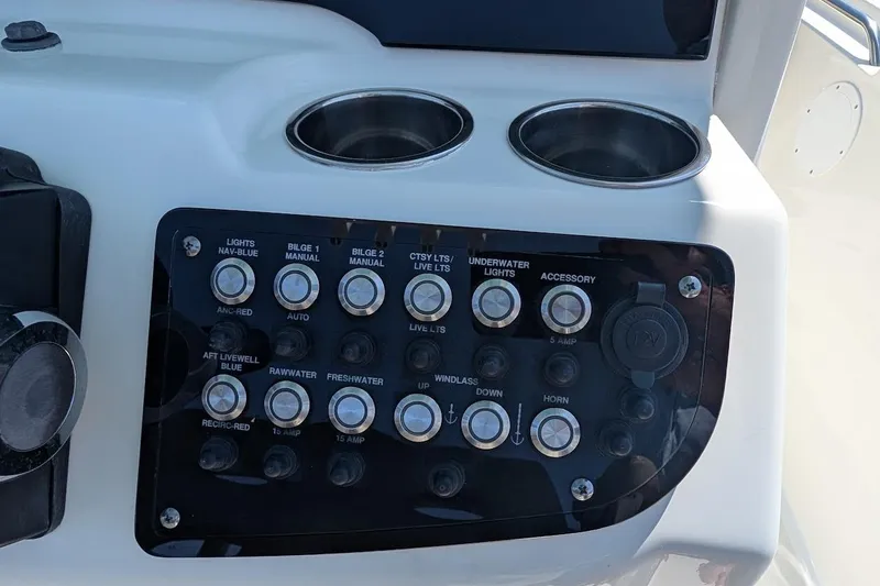 Slide: The Image of Control panel of a 2020 NauticStar 2602 Legacy boat with labeled switches. - 12