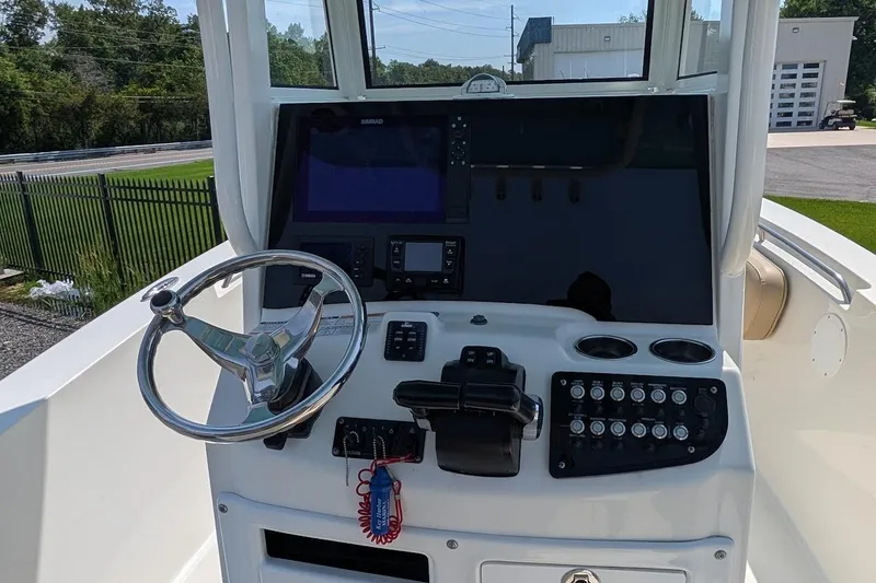 Slide: The Image of 2020 NauticStar 2602 Legacy boat helm with steering wheel and control panel. - 5