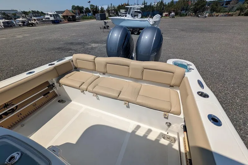 Slide: The Image of 2020 NauticStar 2602 Legacy boat with beige seating and dual outboard motors. - 3