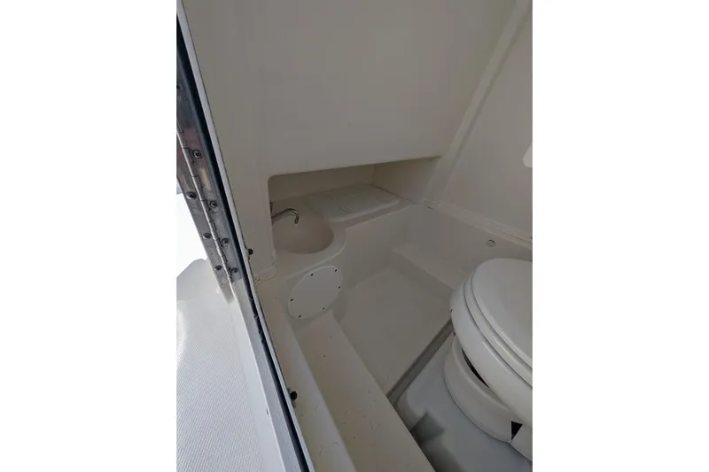 Slide: The Image of 2020 NauticStar 2602 Legacy boat interior with compact marine toilet and sink. - 20