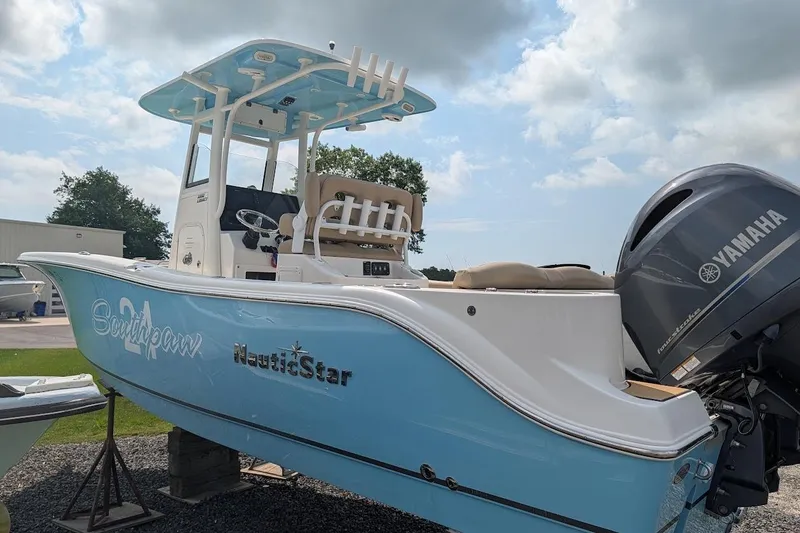 Slide: The Image of 2020 NauticStar 2602 Legacy boat with Yamaha engine, light blue hull, and T-top. - 2