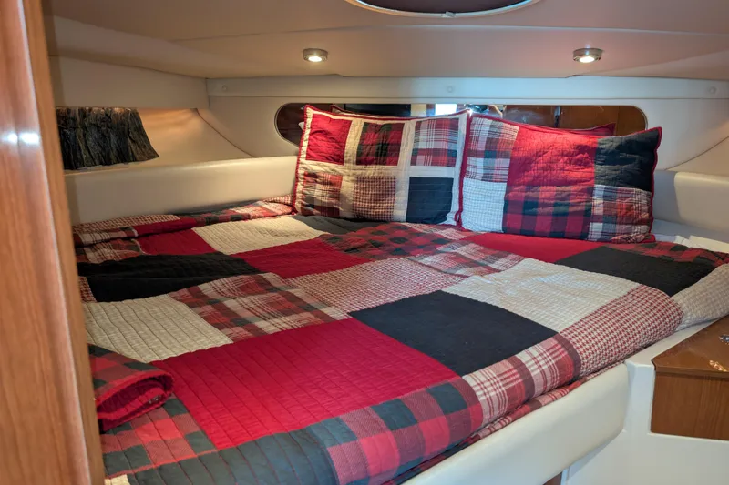 Slide: The Image of Cozy cabin interior of 2005 Regal Commodore 3560 IO with plaid bedding. - 11