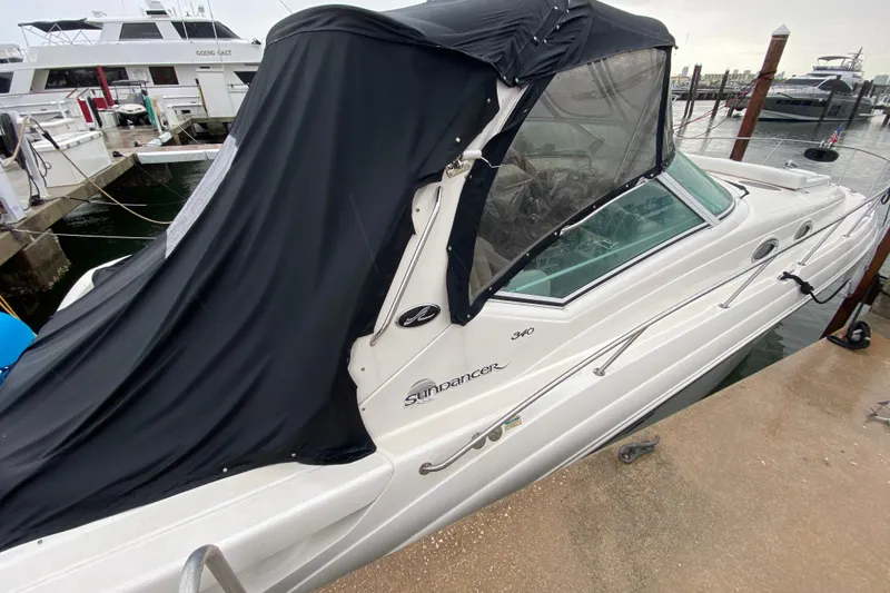 Slide: The Image of 2004 Sea Ray 340 Sundancer boat docked with black canopy cover. - 14
