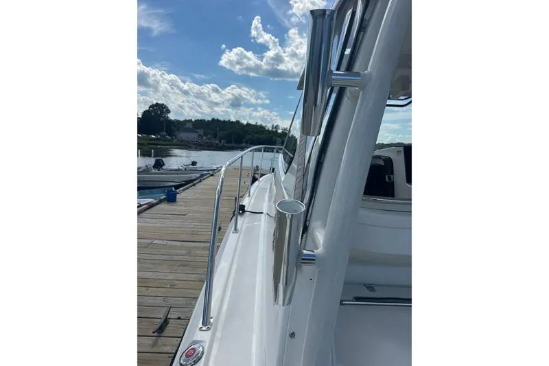 Slide: The Image of 2022 Pursuit OS 325 Offshore boat docked, showcasing sleek design and stainless steel features. - 47