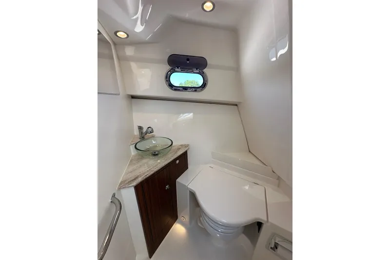 Slide: The Image of 2022 Pursuit OS 325 Offshore boat bathroom with modern sink and compact toilet. - 34