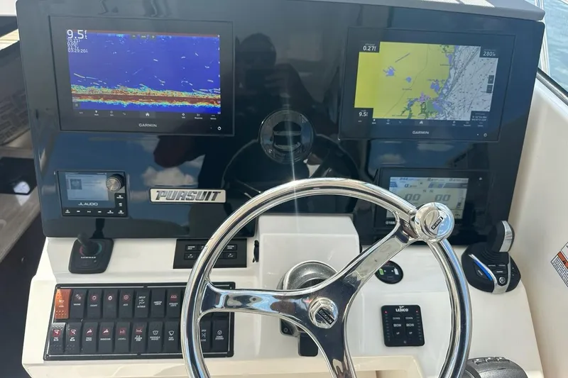 Slide: The Image of Helm of 2022 Pursuit OS 325 Offshore boat with Garmin navigation displays and controls. - 13