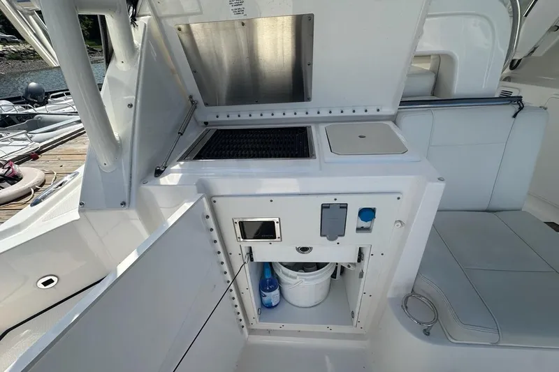 Slide: The Image of 2022 Pursuit OS 325 Offshore boat interior with kitchenette and seating area. - 37
