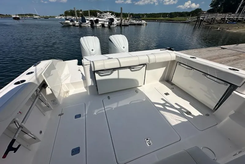 Slide: The Image of 2022 Pursuit OS 325 Offshore boat deck with seating, docked at a marina. - 41