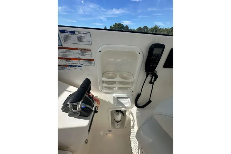 Slide: The Image of 2022 Pursuit OS 325 Offshore boat cockpit with controls and communication equipment. - 17
