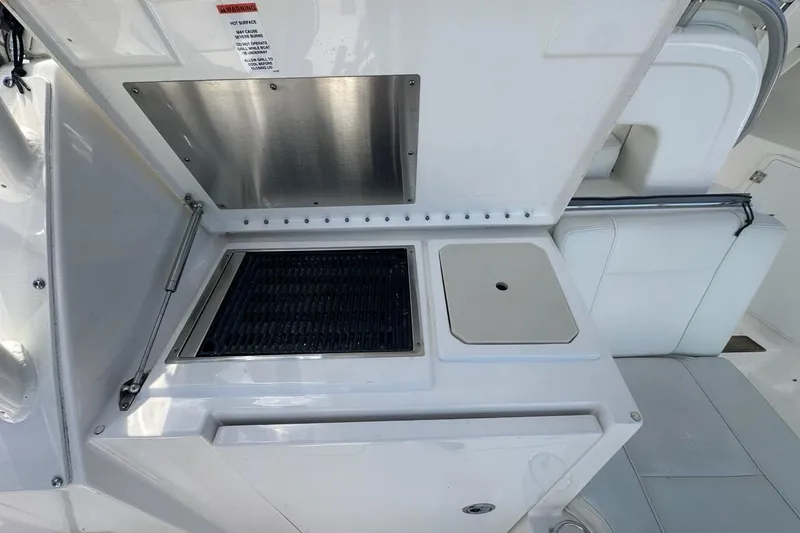 Slide: The Image of 2022 Pursuit OS 325 Offshore boat grill and sink setup on deck. - 38