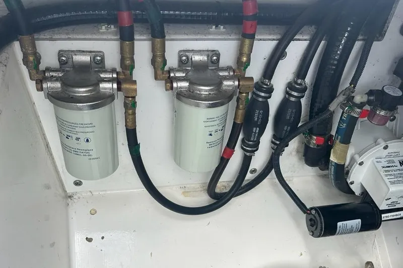 Slide: The Image of Engine compartment of a 2022 Pursuit OS 325 Offshore boat, showing fuel filters and hoses. - 50