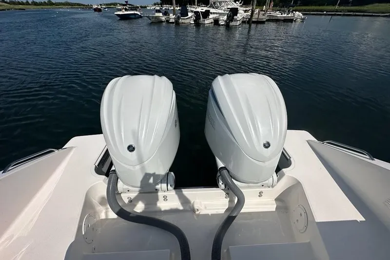 Slide: The Image of Twin outboard engines on a 2022 Pursuit OS 325 Offshore boat, docked in a marina. - 45