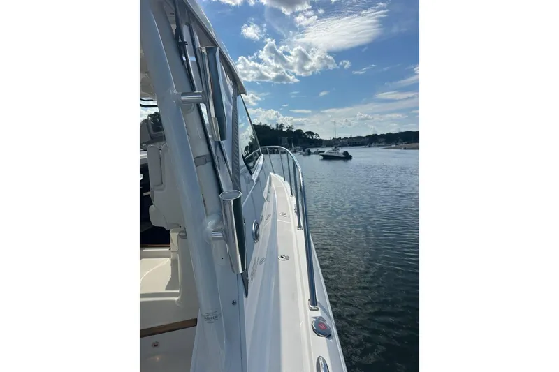 Slide: The Image of 2022 Pursuit OS 325 Offshore boat docked on a sunny day, with calm waters and blue sky. - 46