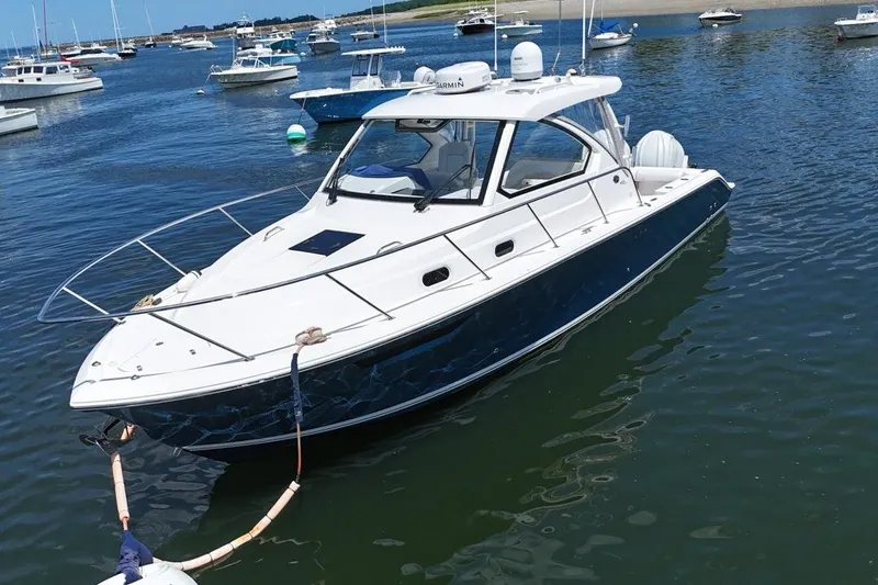 Slide: The Image of 2022 Pursuit OS 325 Offshore boat docked in a marina with other vessels. - 1