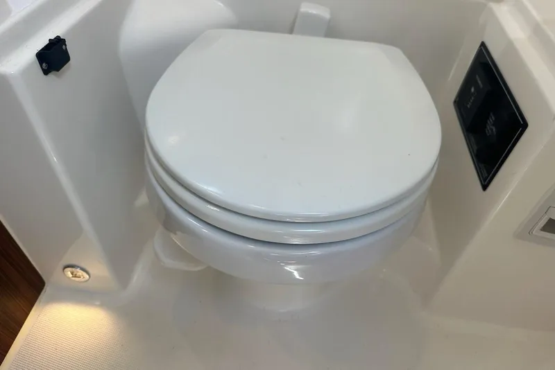 Slide: The Image of 2022 Pursuit OS 325 Offshore boat toilet, white and compact design. - 35