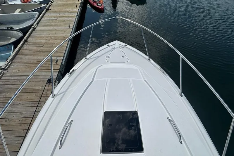 Slide: The Image of Bow view of 2022 Pursuit OS 325 Offshore docked, showcasing sleek design and railing. - 55