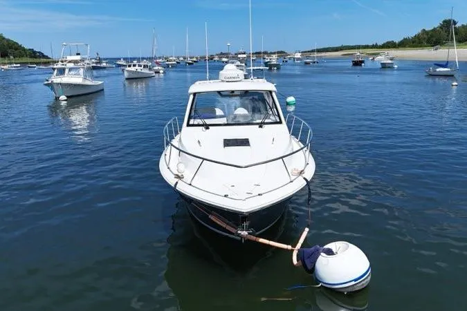 Slide: The Image of 2022 Pursuit OS 325 Offshore boat moored in a scenic harbor with other vessels. - 8