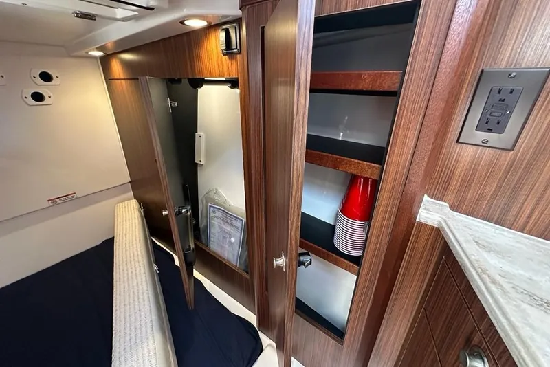 Slide: The Image of 2022 Pursuit OS 325 Offshore cabin interior with wooden cabinetry and storage shelves. - 27
