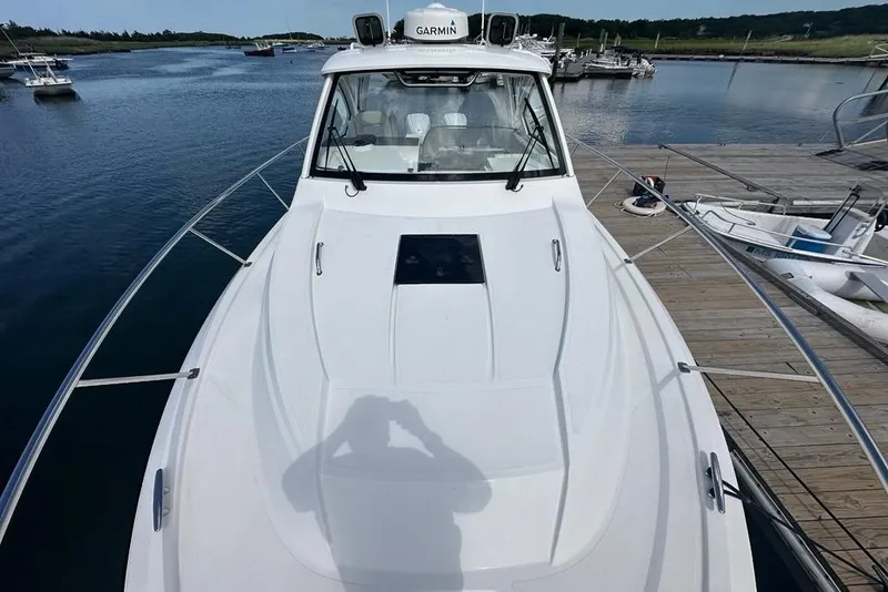 Slide: The Image of 2022 Pursuit OS 325 Offshore boat docked at marina, featuring sleek design and Garmin equipment. - 56