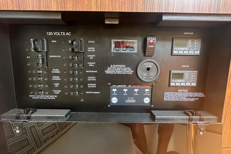 Slide: The Image of Electrical control panel of a 2022 Pursuit OS 325 Offshore boat, featuring various switches and displays. - 25