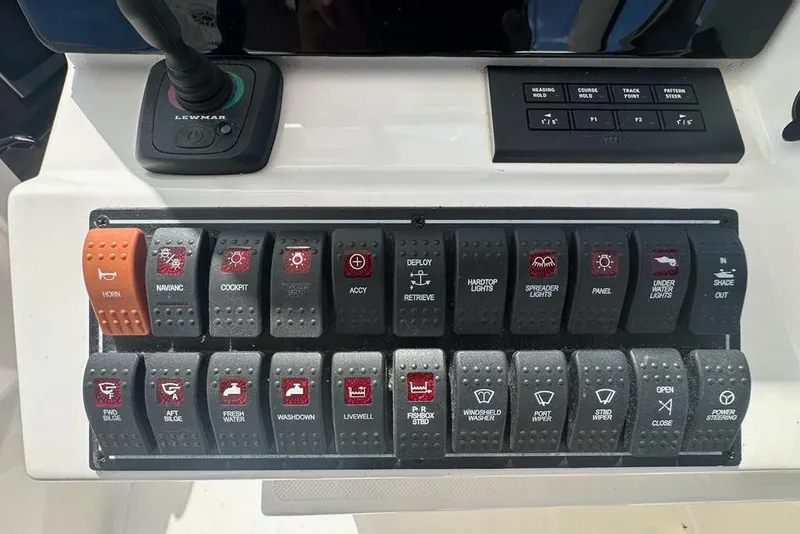 Slide: The Image of Control panel of a 2022 Pursuit OS 325 Offshore boat with labeled switches. - 15