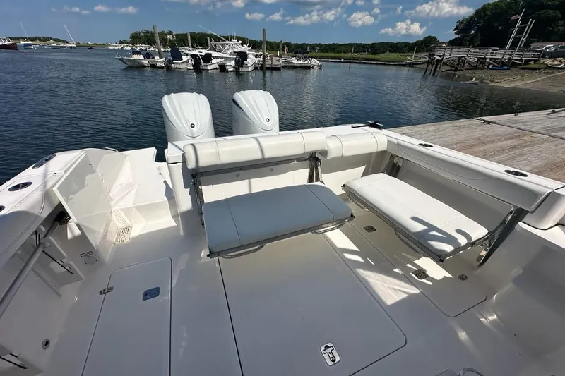 Slide: The Image of 2022 Pursuit OS 325 Offshore boat interior with seating, docked by the water. - 40