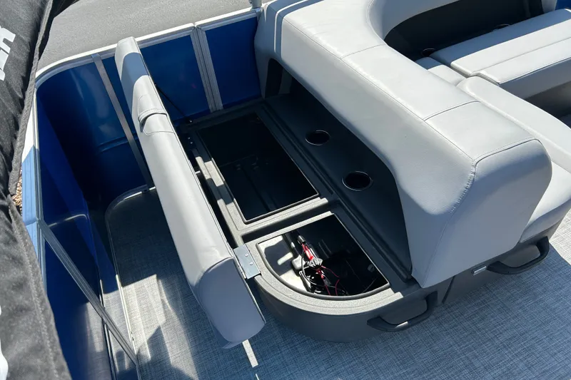 Slide: The Image of 2026 Sun Tracker Party Barge 18 DLX interior with open storage compartments and cup holders. - 20