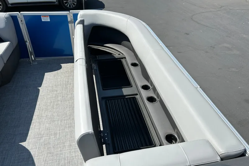 Slide: The Image of 2026 Sun Tracker Party Barge 18 DLX interior with gray seating and cup holders. - 17