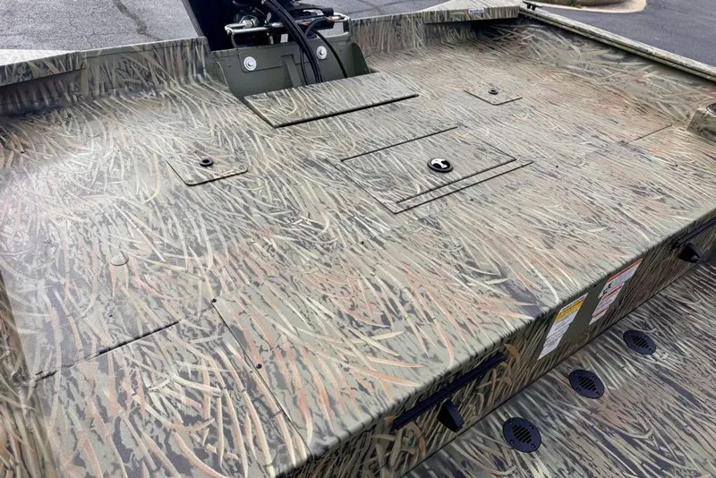 Slide: The Image of Camouflage-patterned deck of 2026 Tracker Grizzly 2072 CC boat, featuring storage compartments. - 14
