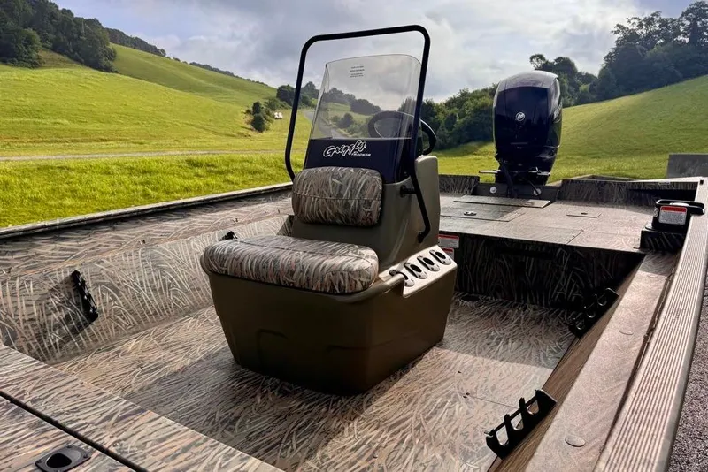 Slide: The Image of 2026 Tracker Grizzly 2072 CC boat with camo interior, set in a scenic landscape. - 9