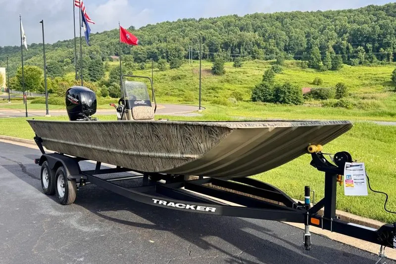 Slide: The Image of 2026 Tracker Grizzly 2072 CC boat on trailer, parked outdoors with scenic background. - 2