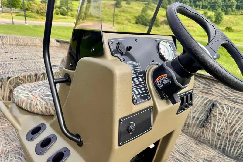 Slide: The Image of 2026 Tracker Grizzly 2072 CC boat console with steering wheel and control panel. - 11
