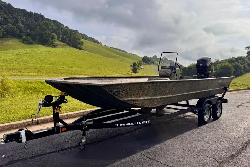 Slide: The Image of 2026 Tracker Grizzly 2072 CC boat on trailer, parked on a scenic road. - 3