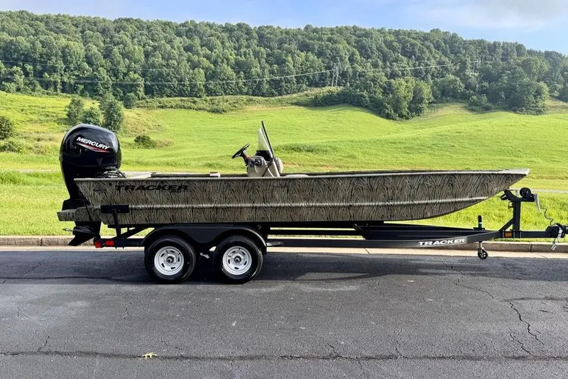 The Image of 2026 Tracker Grizzly 2072 CC boat on trailer, scenic green landscape background. - 0