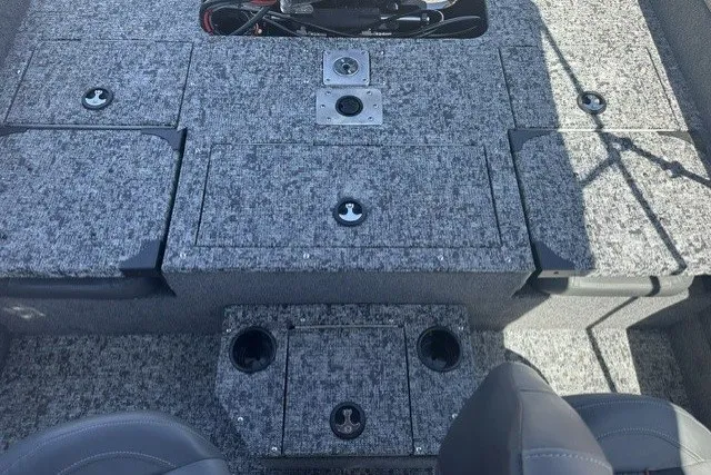 Slide: The Image of 2026 Tracker Targa V-19 Combo boat interior with gray carpeted storage compartments and seating. - 14
