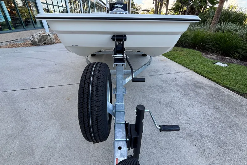 Slide: The Image of Trailer-mounted 2026 Mako Pro Skiff 15 CC boat parked on concrete driveway. - 2