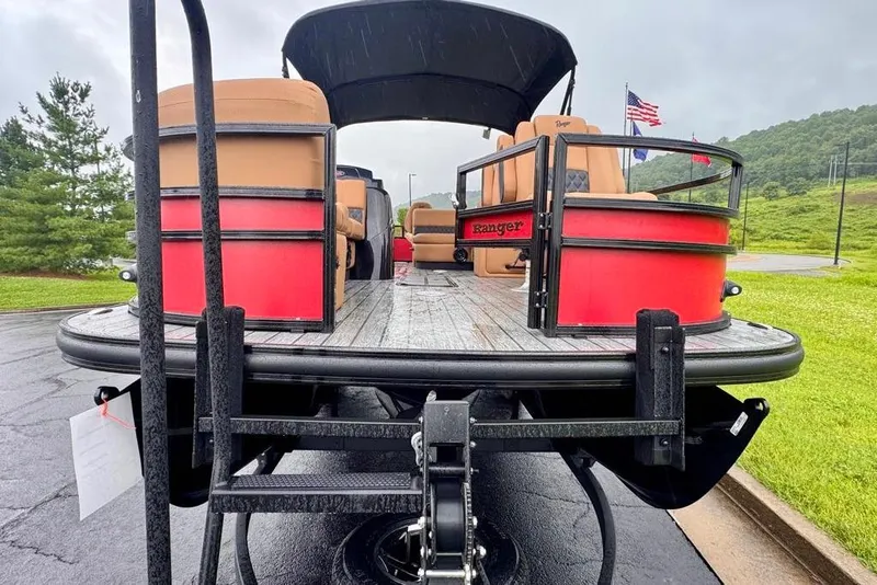 Slide: The Image of 2026 Ranger 223FC pontoon boat on trailer, featuring red and tan seating. - 2