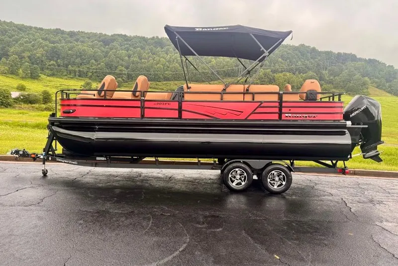 Slide: The Image of 2026 Ranger 223FC pontoon boat on trailer, set against a lush green landscape. - 3
