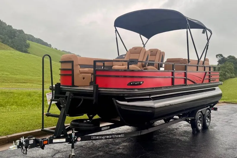Slide: The Image of 2026 Ranger 223FC pontoon boat with canopy on a trailer, parked on a scenic road. - 4